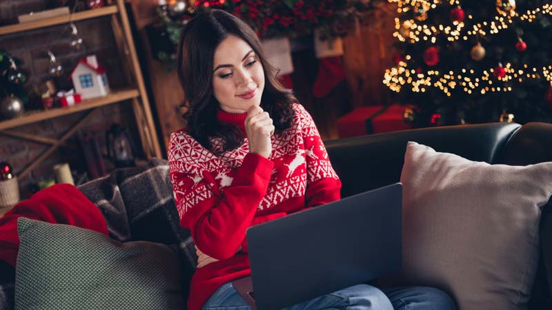 Mulher com portatil a pensar nas compras de natal